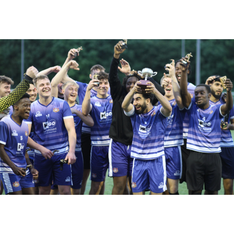Football players in blue kits, celebrating winning a trophy