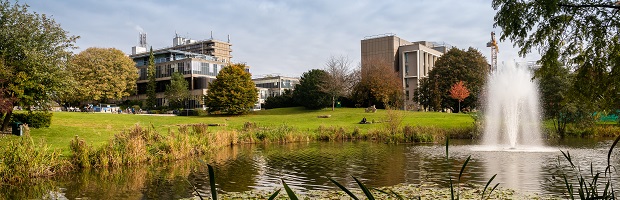 A landscape view of the University's lake with the buildings behind