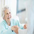 Senior woman holding caregiver's hands