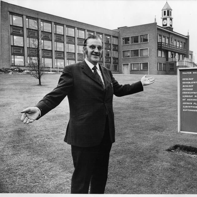man standing infront of university library