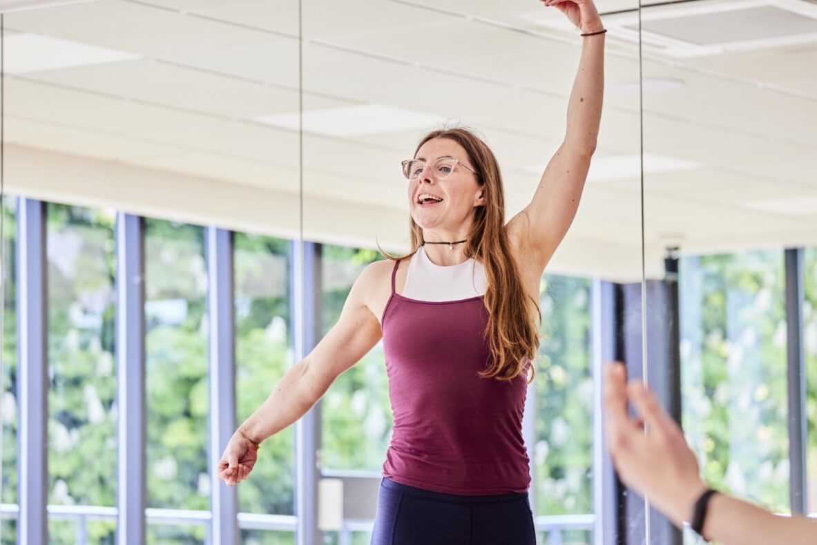 Class instructor demonstrating a position and smiling