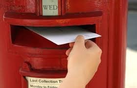 a person posting an envelope through postbox slot