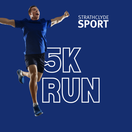 Man in blue top celebrating at finish line, 5K run text in background