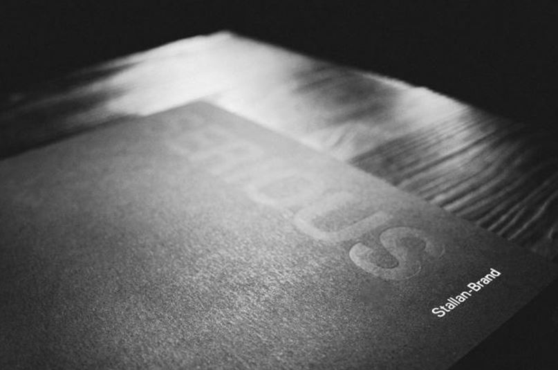 Black and white photo of a book called Serious by Stallan-Brand on a wooden table