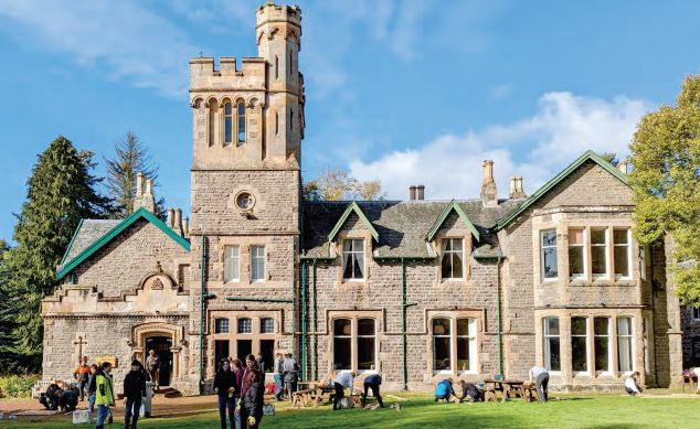 Grand building of Wiston Lodge with blue sky and students in foreground