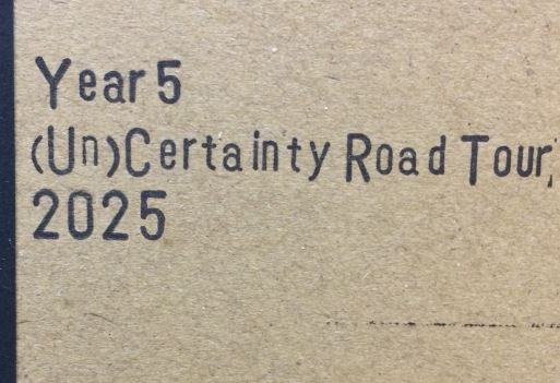 Year 5 (Un)Certainty Road Tour 2025 written in purple text on a brown notebook