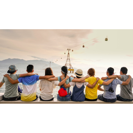 Group of people sitting looking out to a cable car over the sea