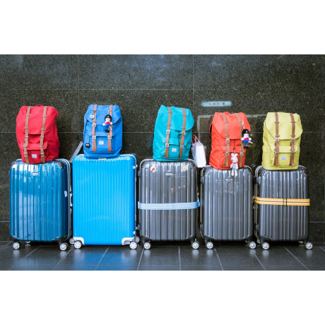 5 suitcases with different coloured backpacks on top