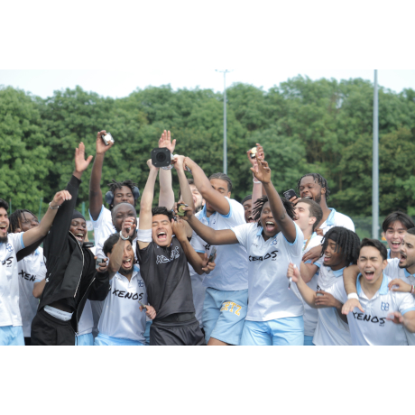 Football team in white celebrating trophy win