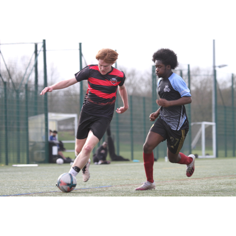 2 footballers running after the ball