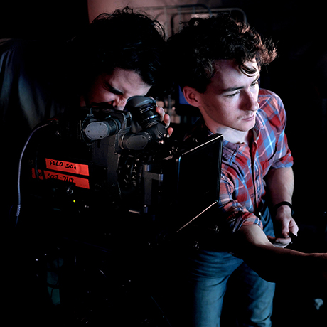 Two young people operating a film camera