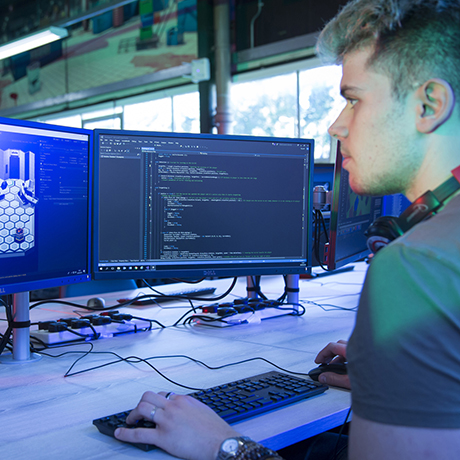 A young person coding on a desktop computer