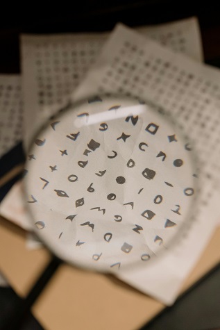 Magnifying glass, looking at codes on a piece of paper