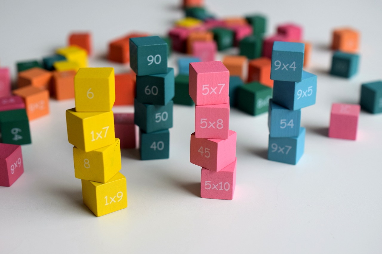 Dice stacked with numbers and sums on, with dice in the background blurred.