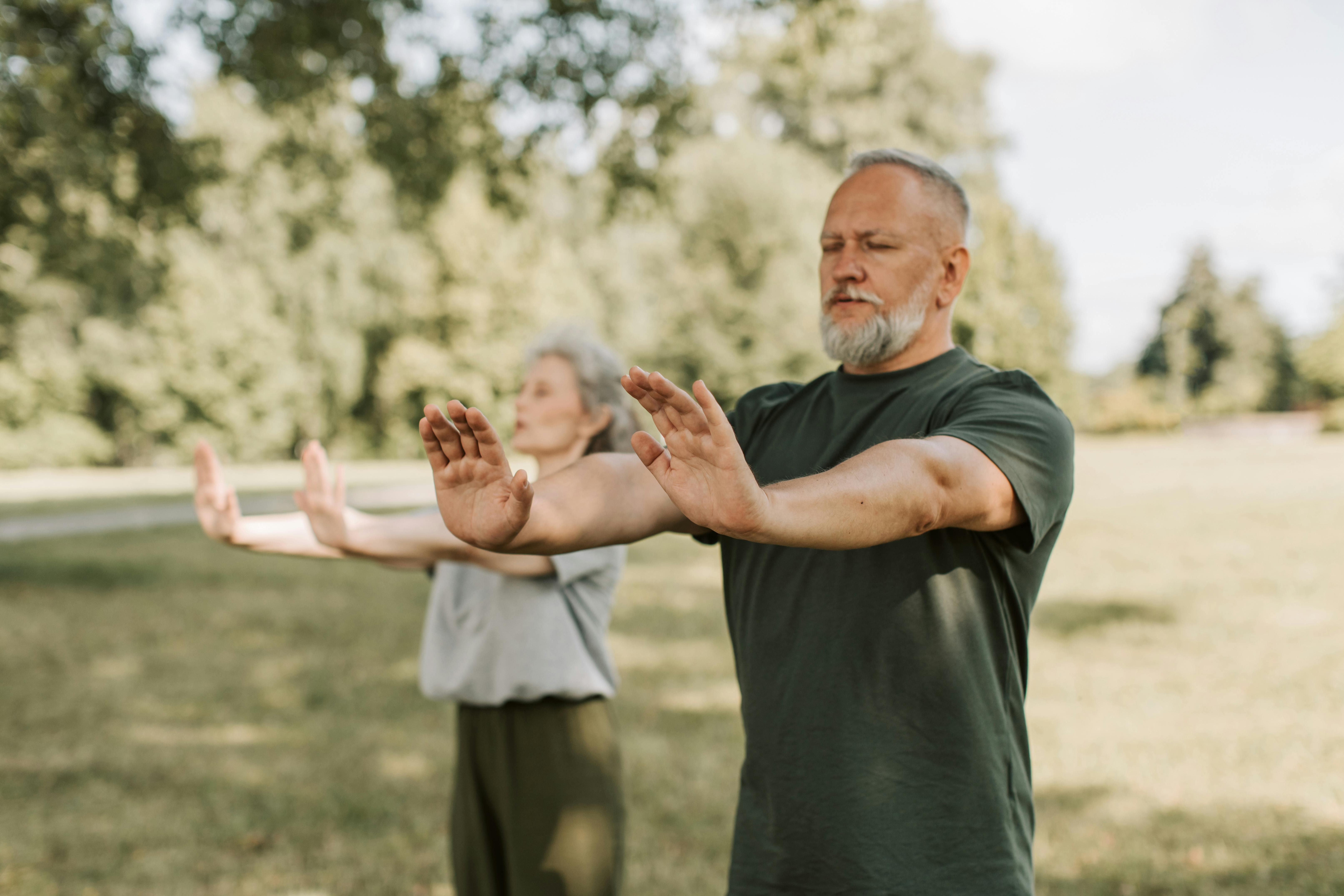 People doing tai chi outside in a field.
