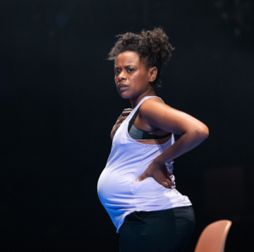 a pregnant woman in a white top is looking off camera