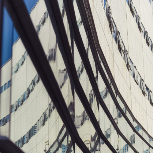 Abstract photo of building windows, reflecting the sky.