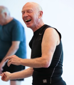 Older gentleman wearing a tshirt with no sleeves, dancing