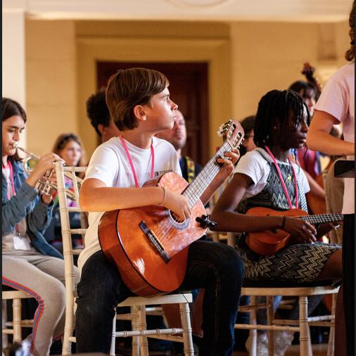 Young people sitting on chiavari chairs playing instruments