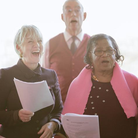 An older gentleman and two older ladies singing
