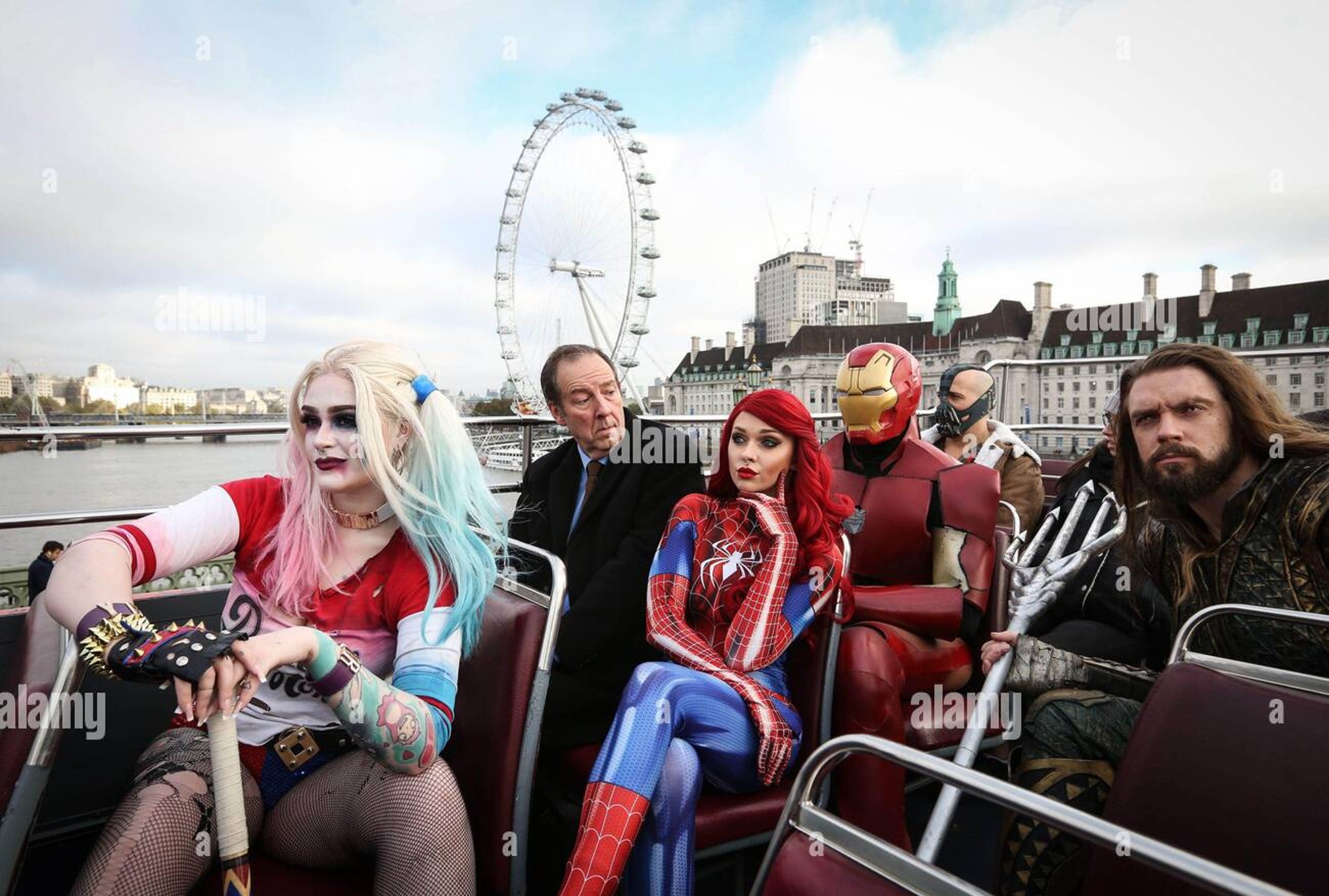 Marvel and DC Characters sitting on open top bus with business man
