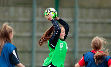 photo of girl throwing a ball in pe lesson