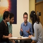 Four people talking around a table.