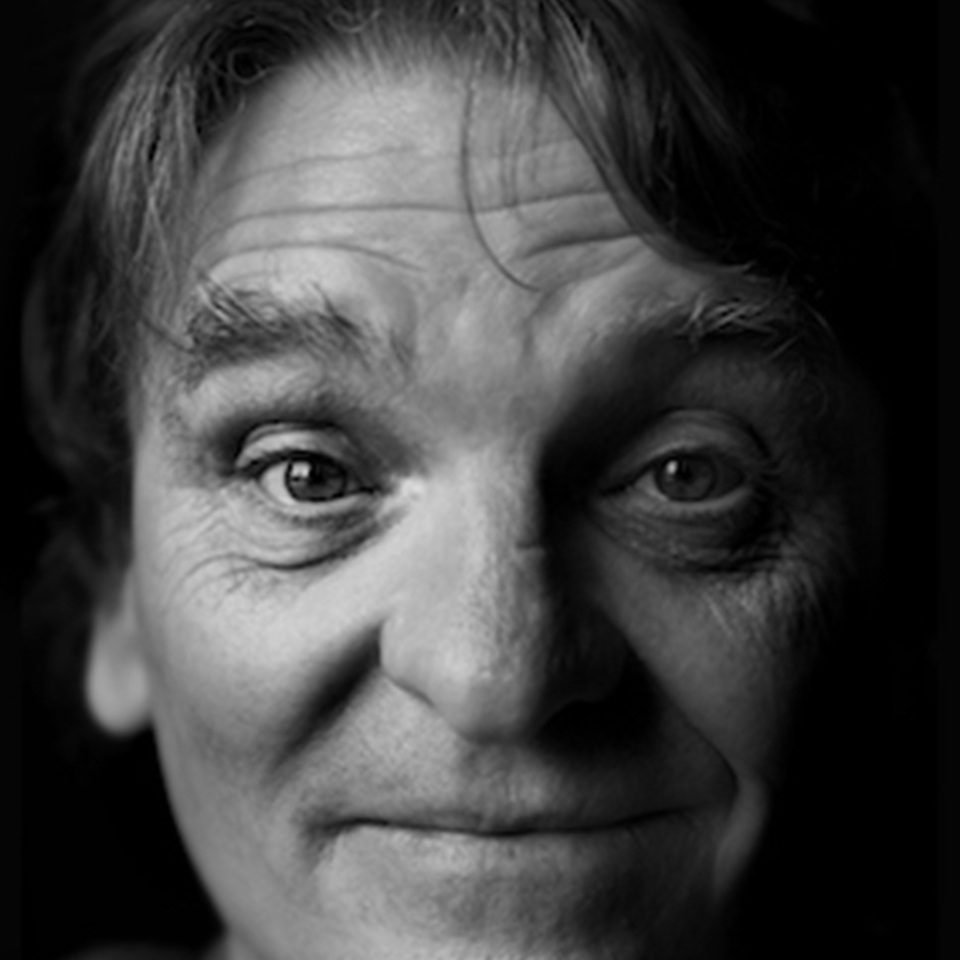 black and white photo of a man looking directly at you smiling