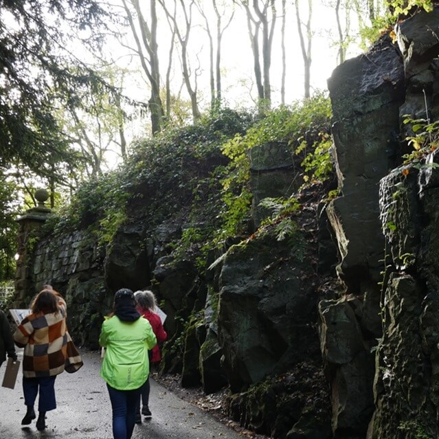 group of people walking through a crevice with rocks either side