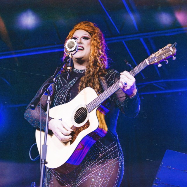 Photographic portrait of Flamy Grant performing with guitar
