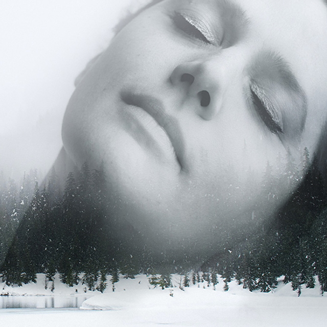 female face with closed eyes with a snowy forest in the foreground