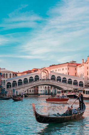 Venice canal with boat and bridge