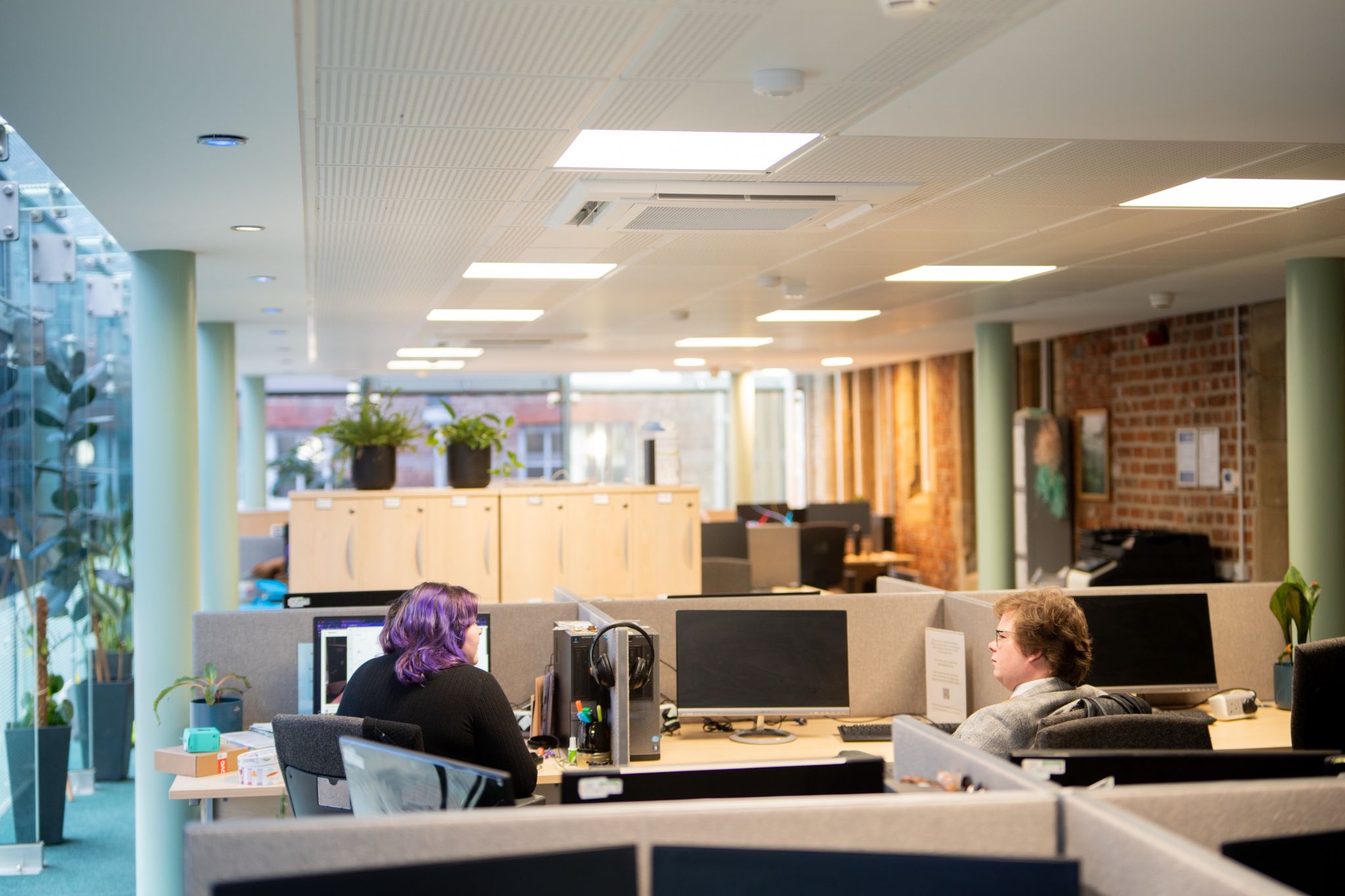 Photo of the graduate centre, shows desks and two students talking