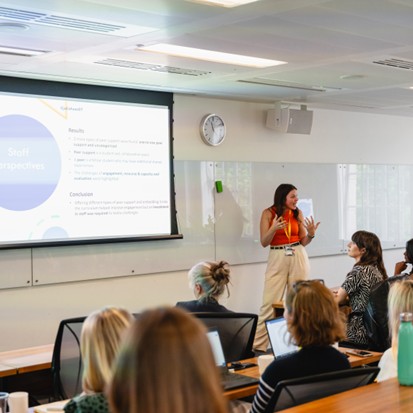 A person presenting in front of a crowd