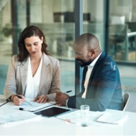 Two people discussing something at a desk